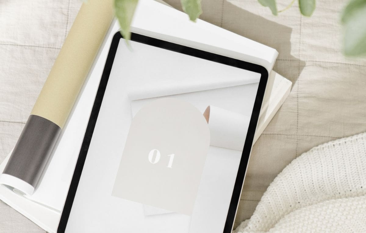 Tablet showing a card numbered 01 on a linen surface, the first step in planning a website